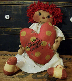 This gentle 20” raggedy is holding her patched up heart in her hands. 