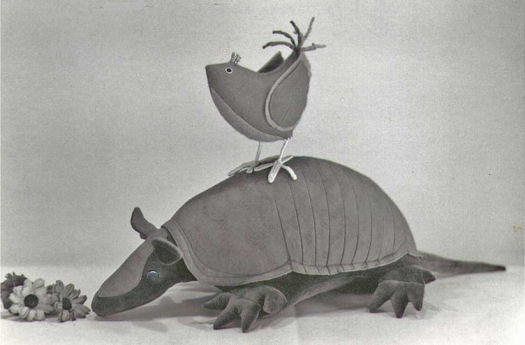 The bird catching a ride on the Armadillo's back stands 4 1/2" tall on wire legs and feet. The button-eyed, 9-banded Armadillo is 13 1/2" long, excluding his 5" tail.